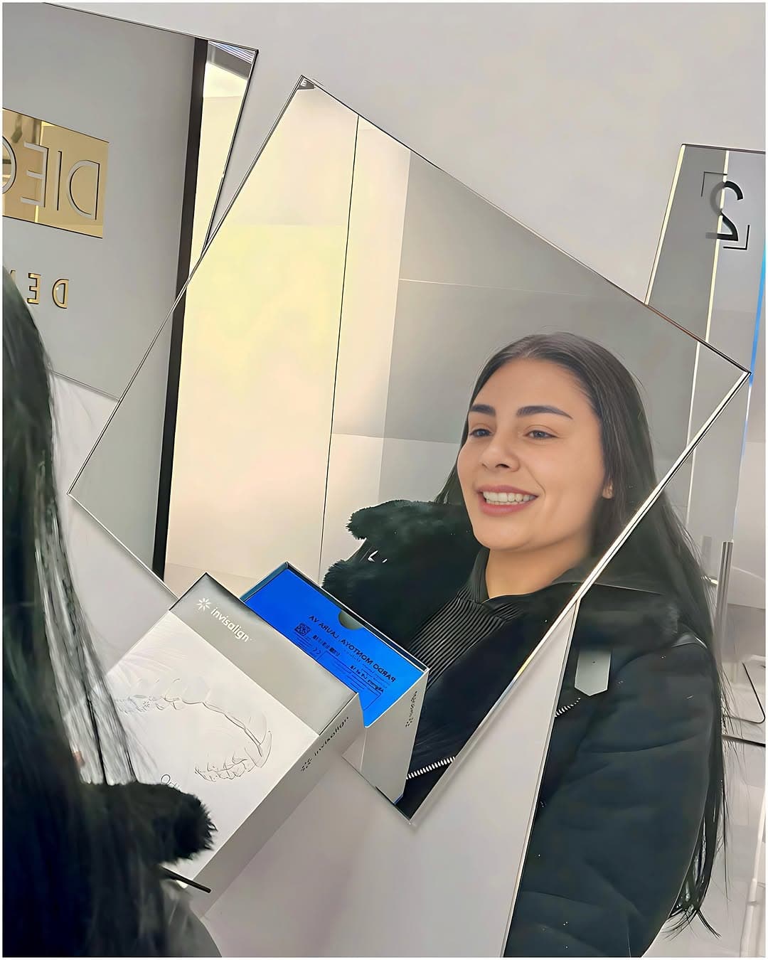 Paciente sonriendo al espejo al terminar su tratamiento