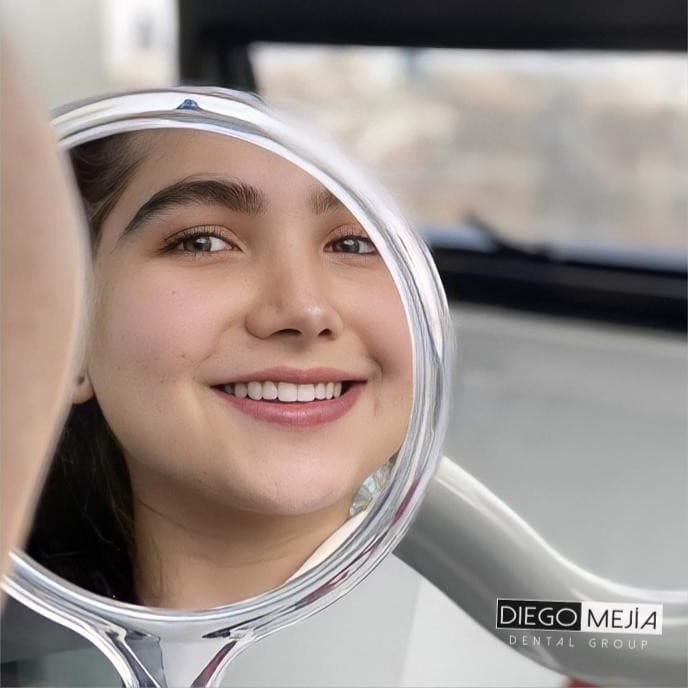 Paciente viendo su nueva sonrisa en el espejo